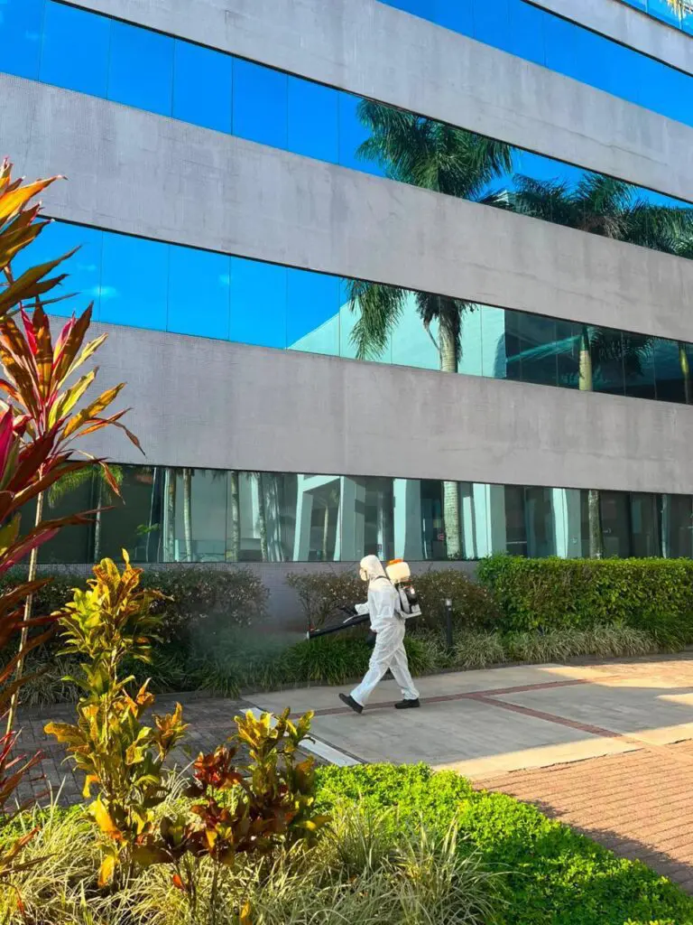Técnico da AJM realizando atomização no jardim de um prédio comercial